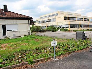 Mit dem Abriss der Hausmeister-Dienstwohnung (links) beginnen kommende Woche die Bauarbeiten am Friedrich-Rückert-Gymnasium Ebern. Unser Bild zeigt den Bereich samt Lehrerparkplatz (im Vordergrund), auf dem der größere Teil des neuen Hauptgebäudes errichtet wird, ehe das bisherige Schulhaus (im Hintergrund) im Sommer 2020 eingerissen wird. Es weicht dem zweiten Abschnitt des Neubaus. Foto: Eckehard Kiesewetter