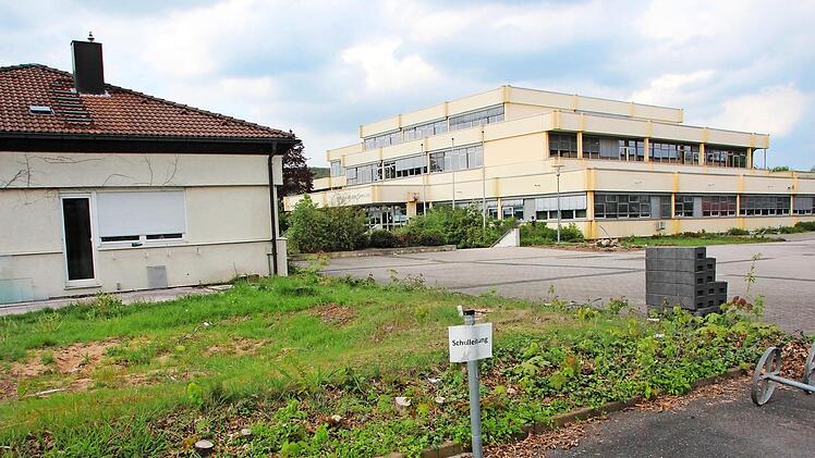 Mit dem Abriss der Hausmeister-Dienstwohnung (links) beginnen kommende Woche die Bauarbeiten am Friedrich-Rückert-Gymnasium Ebern. Unser Bild zeigt den Bereich samt Lehrerparkplatz (im Vordergrund), auf dem der größere Teil des neuen Hauptgebäudes errichtet wird, ehe das bisherige Schulhaus (im Hintergrund) im Sommer 2020 eingerissen wird. Es weicht dem zweiten Abschnitt des Neubaus. Foto: Eckehard Kiesewetter