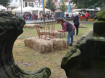 Nina-Regina Nötzelmann bereitete am Samstagvormittag an der Stadtpfarrkirche alles soweit vor, dass Korbmarkt-Besucher mit dem Flechten an den Turm-Elementen beginnen konnten. Foto: Popp