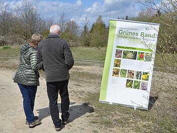 Ein Paar betrachtet ein Info-Banner zum Naturschutzgroßprojekt "Das Grüne" Band, dass während der Auftaktveranstaltung der Projektphase II aufgestellt worden war. Foto: Rainer Lutz