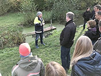 Gunther Haas erläutert Fachleuten und Nachbarn die Vorrichtung, die den Biber dazu bringt, dass er nicht weiterbaut.  Foto: Michael Busch