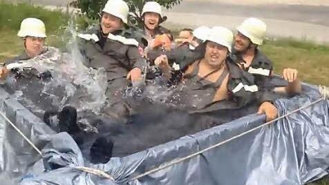 Die Gräfenberger Feuerwehrler plantschen in voller Montur.