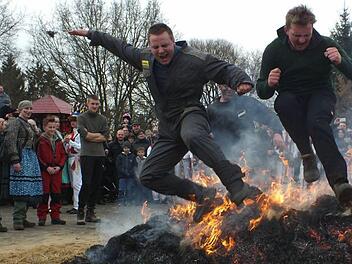 Der Sprung über das heruntergebrannte Feuer aus den Strohbärenmonturen soll Glück bringen.