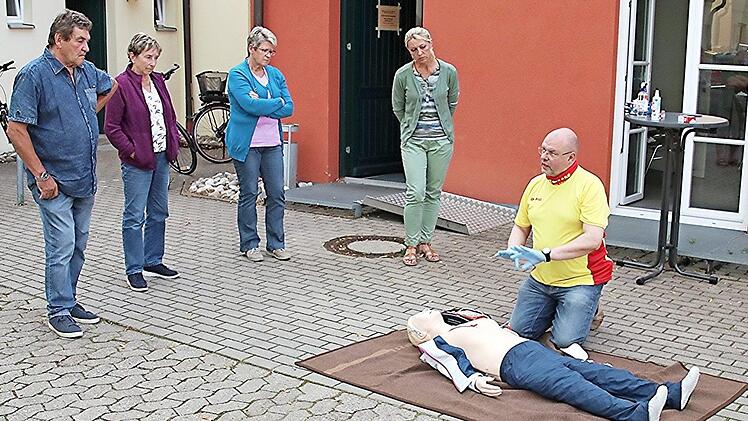Wolfram Girschke von der DLRG-Ortsgruppe Ebern führte den Teilnehmern die praktische Anwendung eines Defibrillators im Hofraum des Hauses der Bäuerin in Heubach vor.  Foto: Helmut Will