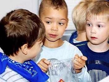 David (von links), Lennox und Pascal beim Bestücken der Tüten mit Süßigkeiten.  Foto: Kindergarten