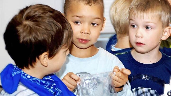David (von links), Lennox und Pascal beim Bestücken der Tüten mit Süßigkeiten.  Foto: Kindergarten