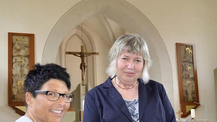 Der handliche kleine Kirchenführer ist fertig. Elfriede Oppel (rechts) zeigt ihn der Pfarrgemeinderatsvorsitzenden Claudia Benkert. Im Hintergrund ist das Geburtstagskind zu sehen: das 500 Jahre alte Riemenschneider-Kruzifix. Fotos: Kathrin Kupka-Hahn