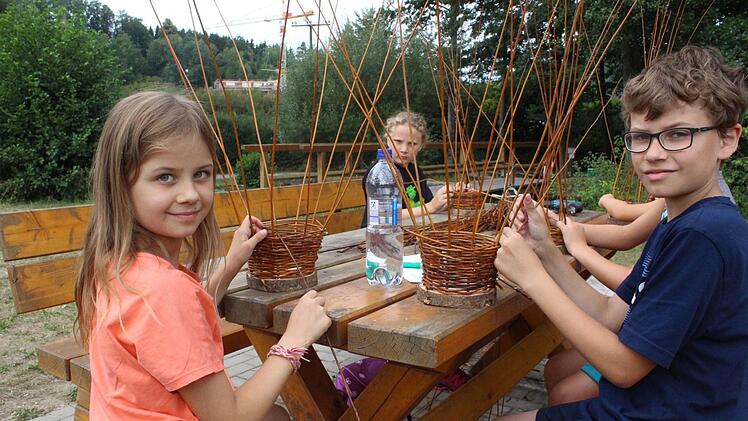 Annika und Christoph (vorne) haben schnell den Bogen heraus und helfen anschlie&szlig;end den anderen Kindern beim Weidenflechten.  Foto: Roland Dietz