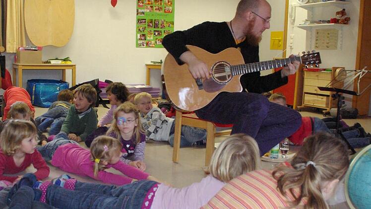 Carlo Hilsdorf war für die Aktion Weltretterkids in Aschach und spielte dort selbstkomponierte Lieder. Unser Bild zeigt die Mädchen und Jungen in Aktion: Die Bäume im Lied sind gefällt.