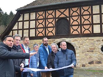 Martin Finzel, Rainer Scholz, Marten Büttner, Chris Loos, Sebastian Sonnauer, Karl-Heinz Glodschei und Rainer Mattern (von links) machen sich anhand des Planes ein Bild davon, wie sich das künftige Depot in das Gelände neben dem Museum einfügen wird. Foto: Rainer Lutz