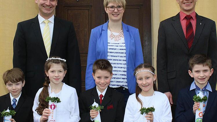 Unterhohenried &mdash; Zwei M&auml;dchen und drei Buben wurden am Sonntag in dem Ha&szlig;furter Stadtteil Unterhohenried zum ersten Mal an den Tisch des Herrn geleitet. Den feierlichen Gottesdienst gestalteten (hinten von rechts) Kaplan Michael Schmitt mit Gemeindeassistentin Juliane Br&uuml;ckner und Gemeindereferent Markus Fastenmeier.  Foto: Ralf Naumann