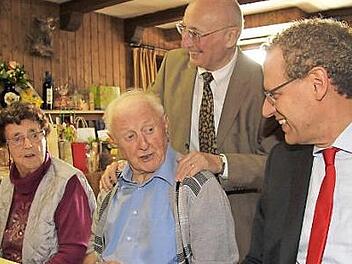 Bürgermeister German Hacker und Altbürgermeister Hans Lang (von rechts) gratulieren Rudi Welker (sitzend) zum 90. Geburtstag. Für Welkers Frau Anna gab es Blumen.  Foto: Richard Sänger