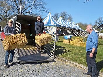 Toni Hübner (links) und Kevin Raab bringen Heu und Stroh für den Zirkus von Georg Frank (rechts). Foto: Rainer Lutz