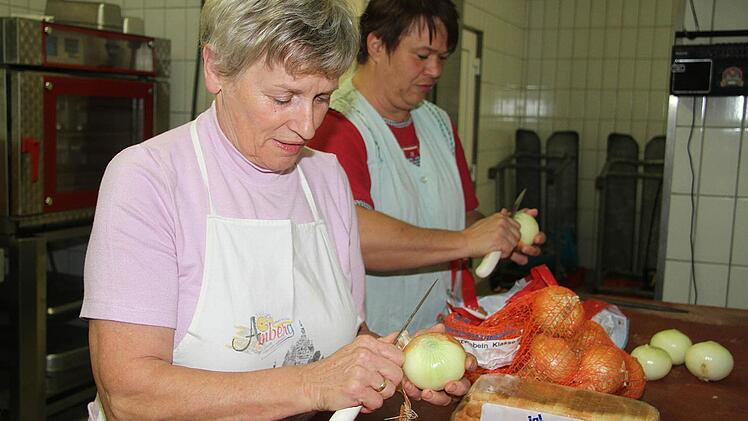 Anni Reuther (links) und Manuela Lindner schneiden Zwiebeln im Akkord - einfach aus Spaß an der Freud. Foto: Sonja Adam