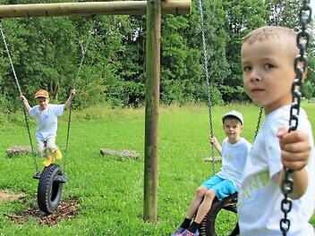 Tayler, Yannick und Alex testen die neue Reifenschaukel. Das Gerät wurde vom Maßbacher Bauhof wieder hergerichtet. Foto: Heike Beudert