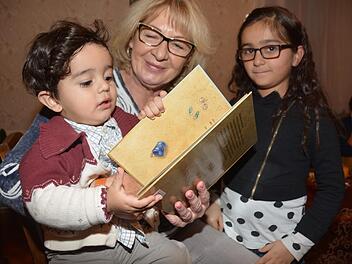 Yusef ist ein aufgeweckter kleiner Junge, der sich für alles Neue einschließlich der Bücher seiner Geschwister interessiert. Familienpatin Sonja Birner verbringt gerne Zeit mit dem Kleinen. Mit im Bild ist Yusefs Schwester Asya. Foto: Dagmar Besand