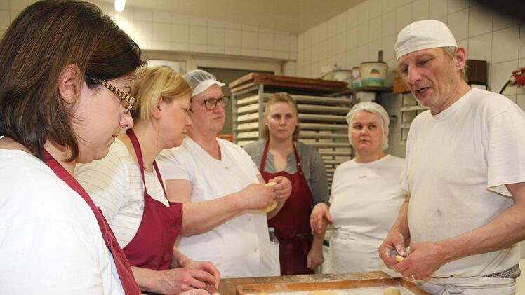 Bäcker Ralf Groß zeigt den 24 Frauen, wie das Formen von fränkischen Küchla und von Krapfen funktioniert. Foto: Sonny Adam