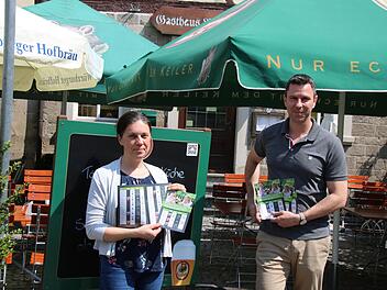 Christine Schikora vom Gewerbeverein und Ron Richter vom Bayerischen Hof zeigen die neuen Flyer, der sich besonders der Außengastronomie widmet.