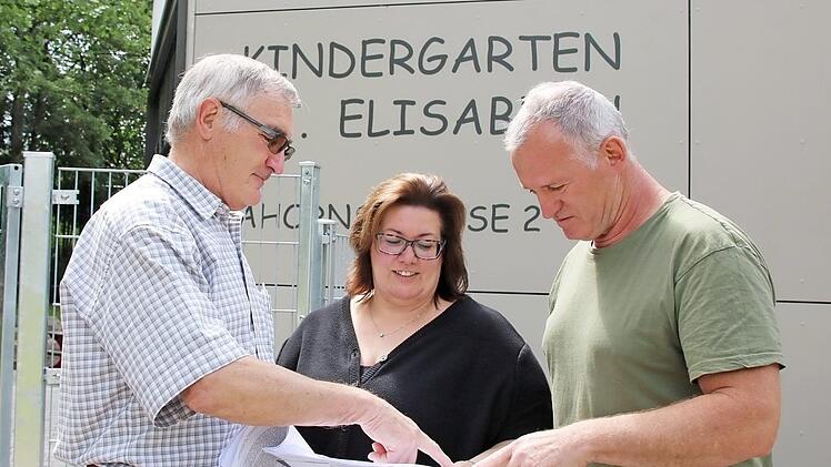 Kirchenpfleger Erwin Hippler (von links), Kindergartenleiterin Andrea Hippler und Architekt Andreas Härder haben alles geplant. Oben ein Blick auf die neuen Sandkästen mit Gebäude dahinter. Foto: Ralf Ruppert