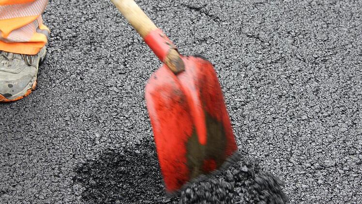 Der Wasserschieber wird unter der frischen Asphaltschicht ausgegraben. Foto: Friedwald Schedel