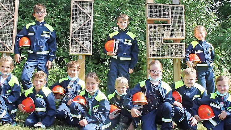 Der Kirchehrenbacher Feuerwehrnachwuchs vor den neuen Insektenhotels &ndash; f&uuml;r das Foto hatten die Kinder ihre Masken kurzzeitig abgenommen.