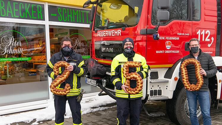 Die Freiwillige Feuerwehr Oberthulba mit 1. Vorstand Tiemo Stürzenberger (links) und Kommandant Lukas Zwecker (Mitte) bekamen von Bäckereigeschäftsführer Johannes Schmitt (rechts) symbolisch die Spende über 250 Euro überreicht. Foto:  Christine Weißenberger
