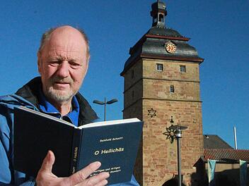 Reinhold Schmitt mit seinem neuen Buch "O Heilichäs" vor dem Stadtturm in seiner Geburtsstadt Bad Staffelstein Foto: Matthias Einwag