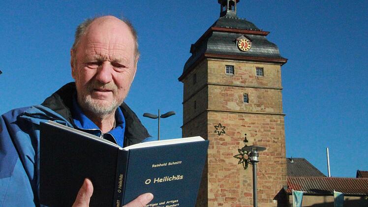 Reinhold Schmitt mit seinem neuen Buch "O Heilichäs" vor dem Stadtturm in seiner Geburtsstadt Bad Staffelstein Foto: Matthias Einwag