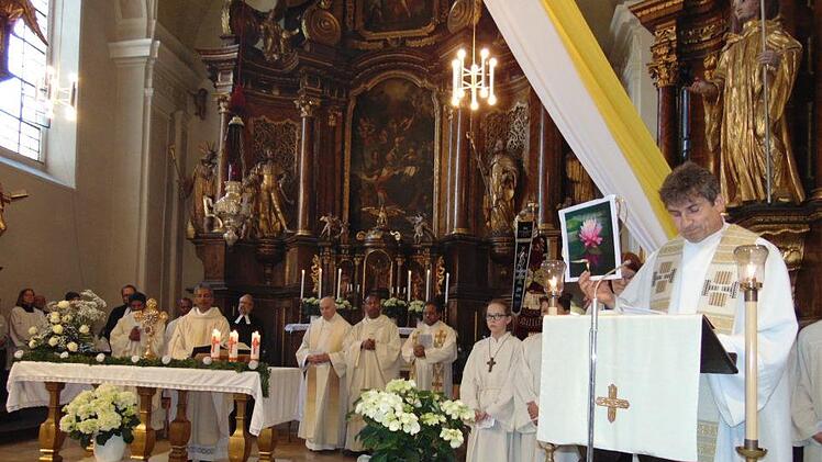 Pfarrer Andreas Hornung zeigt die Lotusblume, das Jubiläumsbild  für   Pater Jimmy. Petra Malbrich