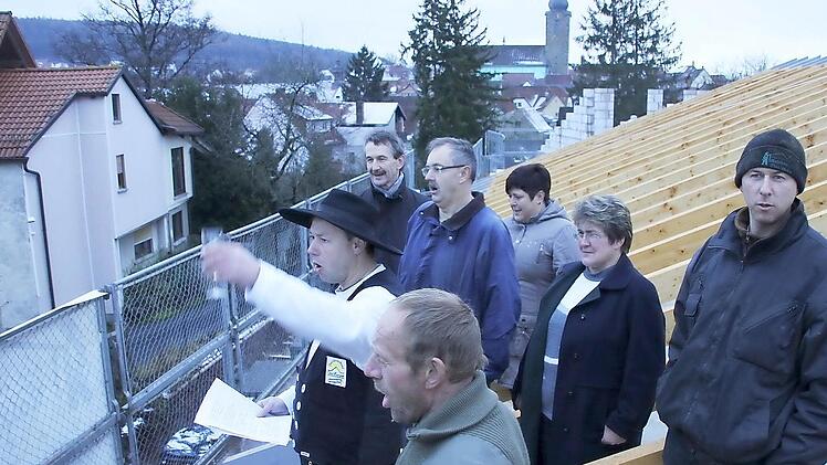 Zimmermeister Fritz Übel (links mit  seinen Mitarbeitern) beim  Richtspruch mit Dr. Norbert Kern, dem Vorstandsvorsitzenden des Diakonischen Werkes Bamberg-Forchheim, der Leiterin des Sozialpsychiatrischen Zentrums, Karolin Spörl, und Zweiter Bürgermeisterin Gabriele Rögner (hintere Reihe von links). Foto: Ralf Kestel