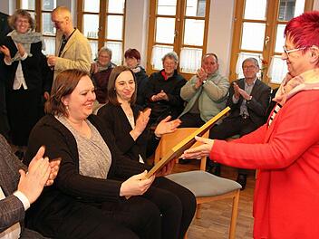 Ein Bild der Bucher Kirche soll Pfarrerin Kaeppel an ihre Zeit in dem Lichtenfelser Ortsteil erinnern. Beate Bauer überreichte ihr auch ein Notfallpaket für alle Fälle. Foto: Joachim Wegner