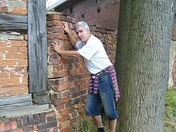 Udo Pörschke an der Mauer eines alten Guthofs von Göritz: Hier wurde sein Großvater mit anderen Kriegsgefangenen kurzfristig einquartiert. Foto: pr