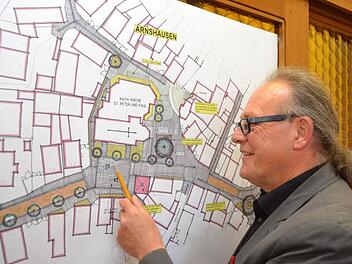 Stadtplaner Wolfgang Russ erläutert, wie die Ortsmitte von Arnshausen aussehen soll. Foto: Peter Rauc