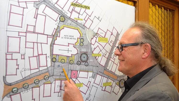 Stadtplaner Wolfgang Russ erläutert, wie die Ortsmitte von Arnshausen aussehen soll. Foto: Peter Rauc