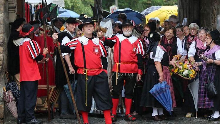 Geschützt vor den Regenmassen stellten sich die Teilnehmer des Festumzugs im Geyersberger Torbogen auf.  Fotos: Bettina Knauth