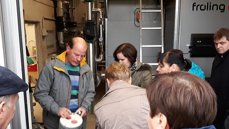 Reiner Zapf-Willmer von der Energiegenossenschaft Oberleiterbach gibt den G&auml;sten aus Polen Einblicke in die Funktionsweise des innovativen Nahw&auml;rmenetzes. Foto: Energievision Franken