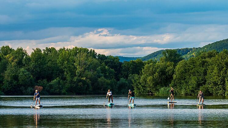 Am Abend hat der Anfänger-Kurs freie Fahrt auf dem Sander Baggersee. Sobald sich die Teilnehmer auf dem Brett sicherer fühlen, steht einem kleinen Rennen nichts im Weg. Foto: Julia Scholl