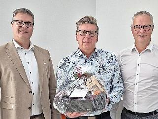 Vorstandsmitglied Markus Feser (links), und Werner Burkard (rechts) verabschieden Matthias Schmitt in den Ruhestand.