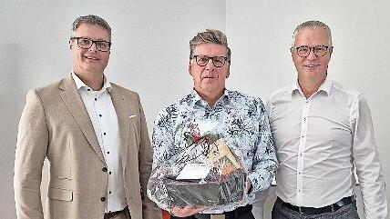 Vorstandsmitglied Markus Feser (links), und Werner Burkard (rechts) verabschieden Matthias Schmitt in den Ruhestand.