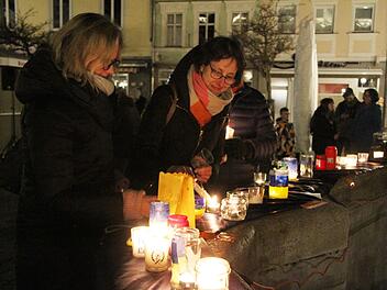 Auf dem Brunnenrand brannten Kerzen. Viele Kulmbacher entzündeten ein Licht für den Frieden. Foto: Sonny Adam