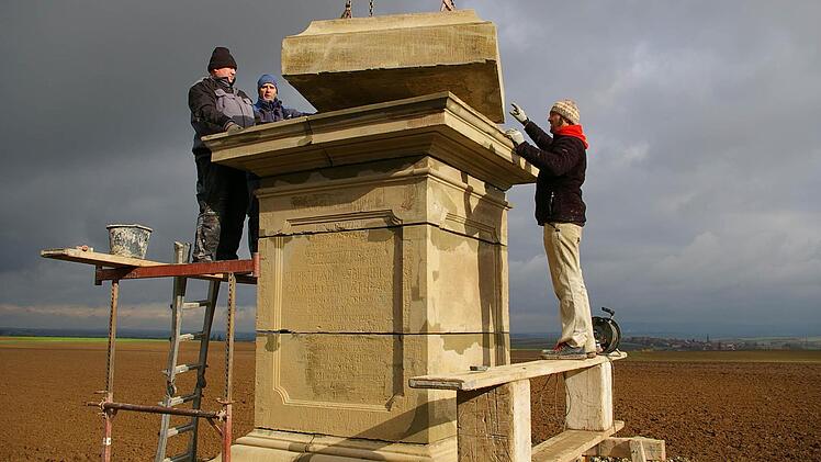 Feinarbeit mit hohen Gewichten: Die Restauratoren Arno Dankwardt, Thomas Wallrapp und Veselin Pusic passen das eine Tonne schwere Mittelstück exakt auf den Sockel der Pyramide.  Fotos: Tom Müller