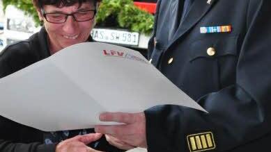 Unter dem Applaus der Gäste überraschte Kreisbrandrat Ralf Dressel die Mutter des Pfarrweisacher Kommandanten, Ute Bock, mit der Ehrenmedaille des Landesfeuerwehrverbandes Bayern für deren ehrenamtlichen Einsatz beim Feuerwehrhaus. Foto: Simon Albrecht