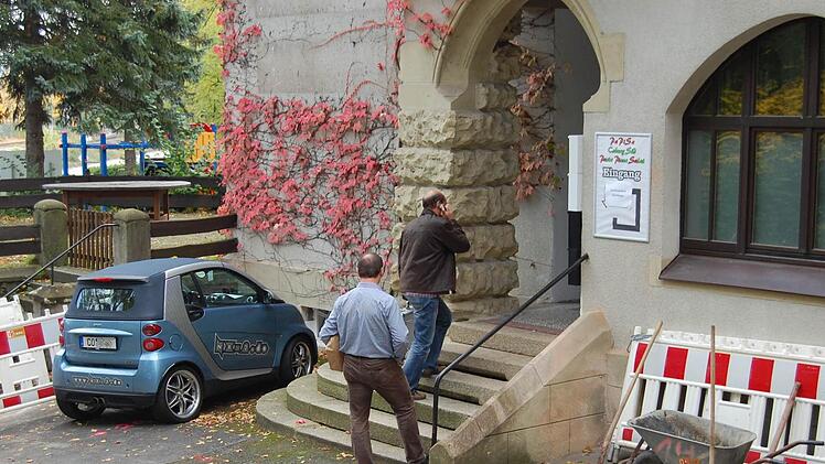 Zwei Mitarbeiter der Spurensicherung betreten am Montagvormittag das Alte Schützenhaus. Ob sie etwas gefunden haben, was zur Aufklärung des Falles beitragen kann, war bis gestern Abend nicht bekannt. Links und rechts vom Eingang sind Absperrungen zu sehen, die mit den derzeitigen Bauarbeiten am Gebäude zu tun haben. Fotos: Oliver Schmidt