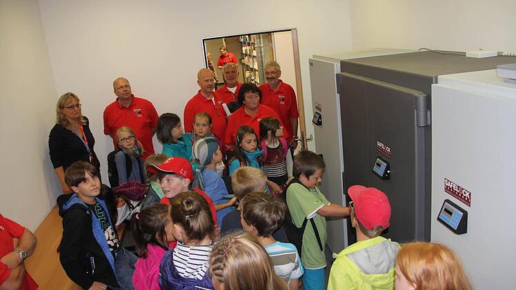 Im Schließfachraum konnten die Kinder von Petra Lerche (hinten links) erfahren, warum Kunden solche anmieten und welche Vorschriften beim Öffnen zu beachten sind.  Foto: Helmut Will