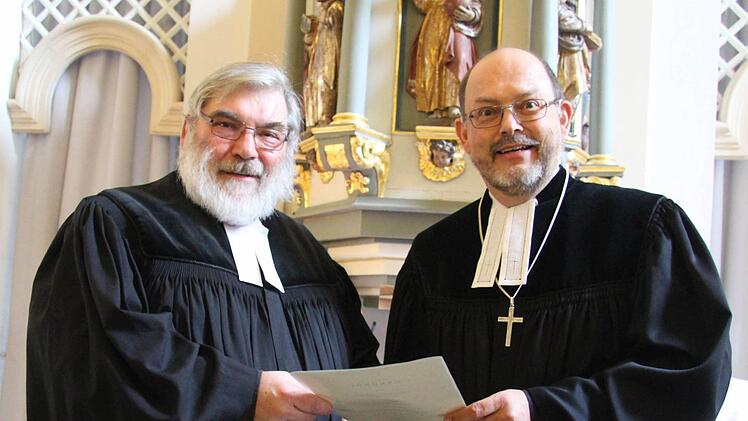 Dekan Thomas Kretschmar (rechts) überreichte Pfarrer Traugott Burmann die Abschiedsurkunde. Foto: Sonny Adam