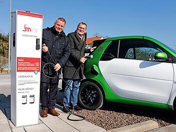 Auf dem Parkplatz der Brose-Arena haben Michael Fiedeldey (links) und OB Andreas Starke eine weitere Elektrolades&auml;ule in Betrieb genommen. Die Lades&auml;ule ist Teil eines europaweiten Ladenetzes mit mehr als 50&nbsp;000 Stationen. Foto: Stadt Bamberg