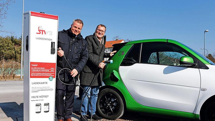 Auf dem Parkplatz der Brose-Arena haben Michael Fiedeldey (links) und OB Andreas Starke eine weitere Elektrolades&auml;ule in Betrieb genommen. Die Lades&auml;ule ist Teil eines europaweiten Ladenetzes mit mehr als 50&nbsp;000 Stationen. Foto: Stadt Bamberg