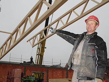 Martin Wolf zeigt, wie der Fachwerkträger präzise abgelassen wird. Foto: Ulrike Müller