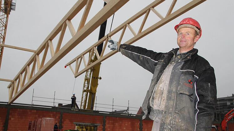 Martin Wolf zeigt, wie der Fachwerkträger präzise abgelassen wird. Foto: Ulrike Müller