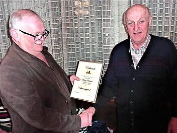 Der Vorsitzende der Flößervereinigung Friesen, Georg Geiger, überreicht Heinz Schmidt (rechts), die Ernennungsurkunde zum Ehrenmitglied. Foto: Gerd Fleischmann